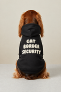 Rear-facing dog wearing a hoodie with the Cat Border Security design